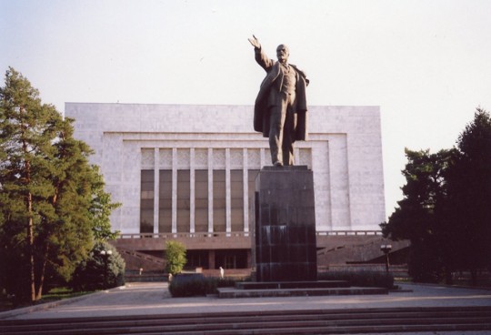 Das umgesetzte Lenindenkmal zeigt heute auf die Amerikanische Universität von Zentralasien (AUCA)